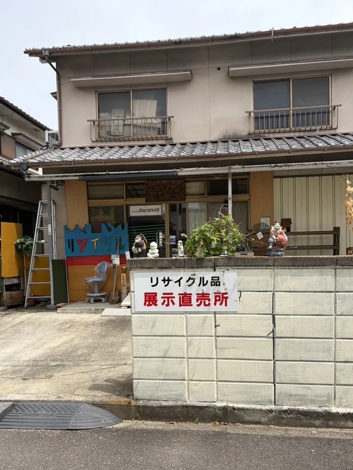 無人販売所の外観。手作りの看板と「リサイクル品 展示直売所」の案内板が目印